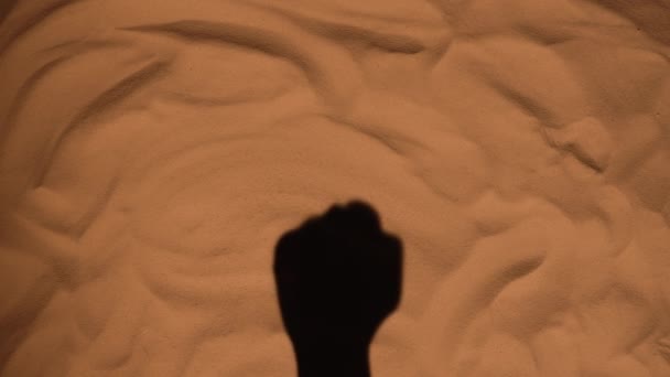 Shadow of a womans hand on sand of beach showing gesture fuck you. Close up silhouette of a female hand. Summer holiday by the sea, vacation enjoying the beach. Tourism season. Slow motion. — Vídeo de Stock