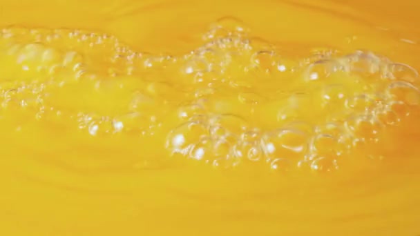 一股新鲜挤压的天然橙汁倒入,形成气泡.美味的新鲜柑橘类果汁异国情调的饮料早餐天然膳食的背景。慢动作靠近点. — 图库视频影像