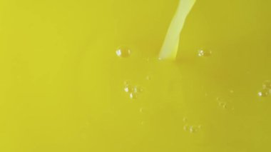 Sarı portakal suyunun yukarıdan görünüşü kabarcıklar oluşturuyor. Limonlu meyve suyu ya da limonata yakın çekim. Kahvaltıda taze sıkılmış tropik içeceklerle dolu bir arka plan. Yavaş çekim.