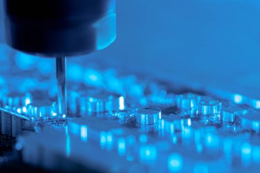 Metal işleten CNC değirmen makinesi. Delme çeliği. Bir sondaj makinesi metali işliyor, bir şekli kesiyor. Detayların modern işleme teknolojisi. Endüstriyel detayları mavi ışıkta kapatıyoruz.