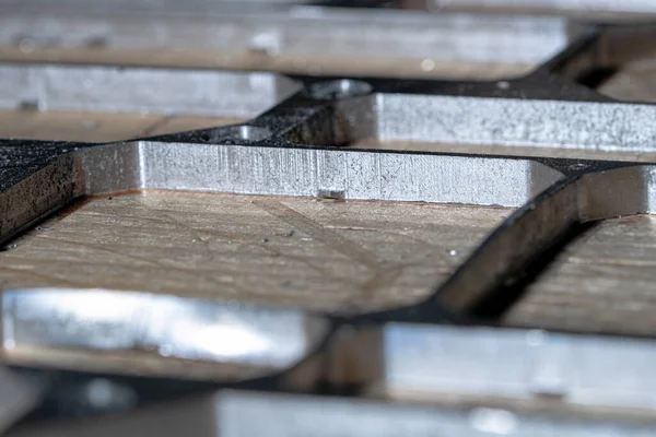 Empty metal molds after milling workpieces. Industrial plant, enterprise. The milling machine produced precise parts from a metal billet according to the program. Detailed close up shot. — Stock Photo, Image