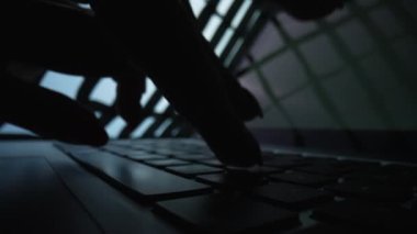 Karanlıkta dizüstü bilgisayarla çalışan bir kadın. Evdeki ofiste klavye kullanarak not defterine yazan serbest çalışan bir kadın. Klavyedeki kadın parmak siluetinin aşırı yakın çekimi. Yavaş çekim.
