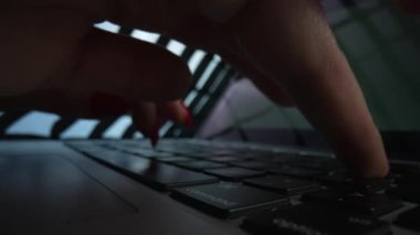 Kadın elleri dizüstü bilgisayarda klavye kullanıyor. Parmaklar daktiloya dokunur. Tablet bilgisayarda çalışan bir iş kadını. Karanlık ofiste kadın ellerini klavyenin üzerine koy. Serbest çalışma, online eğitim. Yavaş çekim.