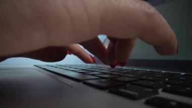 Dizüstü bilgisayarda çalışan bir kadın. Defterdeki tuşları yazan kadın parmaklarını kapat. Dolly, bilgisayar klavyesinde tuşlara basan ve sosyal ağda sohbet eden kadın parmaklarını çekiyor. Yavaş çekim.