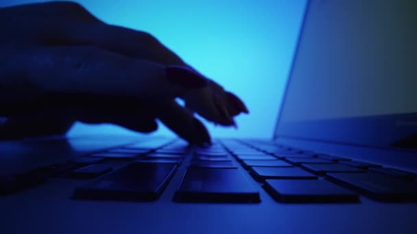在昏暗的办公室，蓝光下，女性手在笔记本电脑键盘上打字的低角度照片。在笔记本上工作的女性。自由、在线教育、聊天、社交网络交流。靠近点. — 图库视频影像