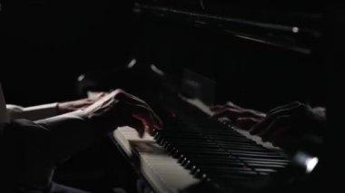 Erkek eller siyah arka planda piyanoda hızlı neşeli müzik çalar. Müzisyen, enstrümanın siyah ve beyaz tuşlarına parmaklarıyla dokunarak müzik melodisi yaratıyor. Kapatın. Yavaş çekim 59.94fps 'te hazır.