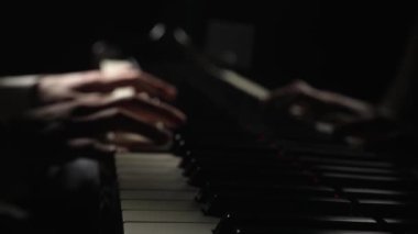 Yetenekli piyanist karanlıkta piyanoda klasik melodi çalar. Erkeklerin bulanık görüntüsü elleri telli klavye enstrümanının tuşlarına dokunuyor. Müzikal sanatçının performansı. Kapatın. Yavaş çekim 59.94fps 'te hazır.