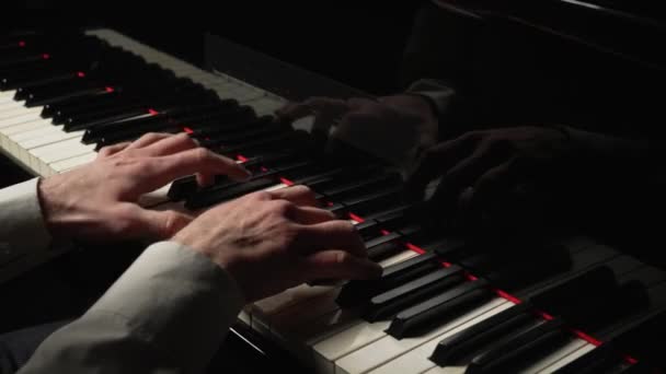 Ο πιανίστας παίζει μουσική στο πιάνο στο σκοτάδι. Ο μουσικός αγγίζει λευκά και μαύρα πλήκτρα εγχόρδων με τα δάχτυλά του δημιουργώντας μια μουσική μελωδία. Τα αντρικά χέρια κοντά. Αργή κίνηση έτοιμη στα 59.94fps. — Αρχείο Βίντεο