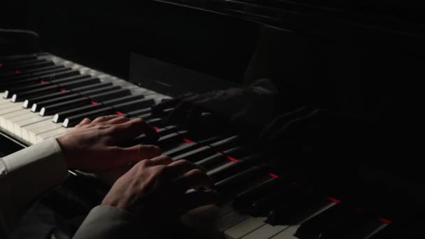 재능있는 피아니스트는 어두울 때 피아노에서 클래식 멜로디를 연주 한다. 손은 건반 악기의 건반에 손을 맞춘다. 음악 아티스트의 전문적 인 공연이죠. 닫아. 59.94fps 에서 느린 동작 준비. — 비디오