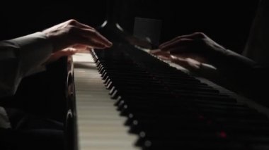 Erkek eller siyah arka planda piyanoda hızlı neşeli müzik çalar. Müzisyen, enstrümanın siyah ve beyaz tuşlarına parmaklarıyla dokunarak müzik melodisi yaratıyor. Kapatın. Yavaş çekim 59.94fps 'te hazır.