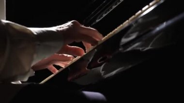 Siyah arka planda piyano çalan adamın düşük açılı görüntüsü. Piyanist müzik aletinin siyah beyaz tuşlarına dokunuyor. Klasik Caz Konseri. Erkek eli yaklaş. Yavaş çekim 59.94fps 'te hazır..