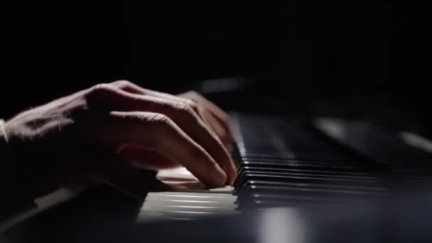 Мужские руки касаются клавиш пианино и играют быструю джазовую мелодию. Пианист играет аккорды, создавая музыку на пианино в темноте. Ключи от музыкального инструмента. Пальцы музыкантов закрываются. Медленное движение готово на 59,94fps. — стоковое видео