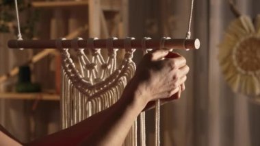 Kadınların elleri boho tarzında makrome örer. Kadın dantel yapmak için pamuk ipliklere düğüm atıyor. Yaratıcı atölye. Modern örgü doğal dekorasyon konsepti. İp ustası. Kapatın. Yavaş çekim.