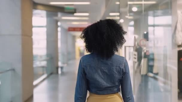 Alışveriş konsepti. Afro-amerikan bir kadın alışveriş merkezinden içeri giriyor ve markalı ürünlerle vitrinlere bakıyor. Kapat.. — Stok video