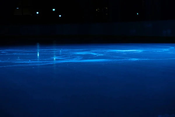 Mjuk, blank yta på en isrink som reflekteras av spotlights. Mörk tom isarena med mjukt blått ljus. Begreppet vintersport spel, hockey, konståkning. Isig bakgrund av hal is. — Stockfoto