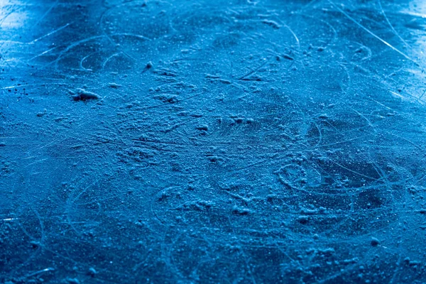 Superficie de hielo en arena deportiva para patinaje artístico o hockey. El fondo de hielo y la textura del hielo se cortan con el patrón y los arañazos de los patines. Detalle de hielo texturizado con nieve en luz azul. De cerca.. —  Fotos de Stock