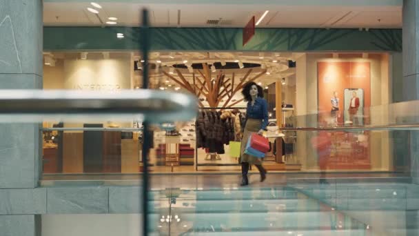 DNYPRO, UCRAINA - 1 DICEMBRE 2021: Belle donne caucasiche e afroamericane camminano con borse colorate in mano nel centro commerciale. Concetto di shopping nei negozi di abbigliamento. Molte vetrine. — Video Stock