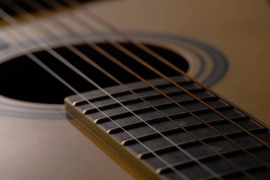 Kahverengi ahşap akustik gitar gövdesi, ses deliği ve telleri var. Yaylı telli müzik aleti, rezonatörü kapat. Klasik klasik gitar..