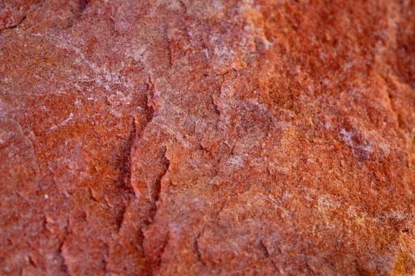 Fondo de textura de piedra natural de granito áspero naranja. Pieza de piedra con patrón texturizado, grietas y rugosidad. Piedra mineral para la construcción. Macro primer plano de la superficie de piedra en relieve. —  Fotos de Stock