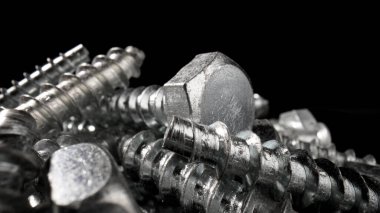 Çelik krom vida yığını. Paslanmaz çelik cıvatalar, masada demir cıvatalar. Metalik sarmal oymacılık. Makro, kapat..