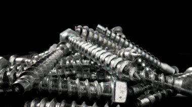 Çelik krom vida yığını. Paslanmaz çelik cıvatalar, masada demir cıvatalar. Metalik sarmal oymacılık. Makro, kapat..