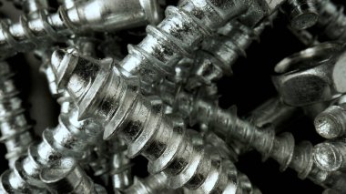 Çelik krom vida yığını. Paslanmaz çelik cıvatalar, masada demir cıvatalar. Metalik sarmal oymacılık. Makro, kapat..