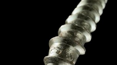 İzole edilmiş siyah arka plandaki paslanmaz spiral vida ipliğinin bir parçası. Metal vida, çelik cıvata ve iplik. Gümüş vida çapası. Spiral süper makro yakın çekim. Yavaş çekim hazır 59.97fps.