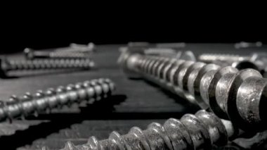 Kamera vidaları, metal başlıklı cıvataları, siyah arka planda duran bağlayıcıları kapatıyor. Çelik krom sunucu bir atölyede ya da hırdavatçıda vidalanır. Süper makro yakın çekim. Yavaş çekim hazır 59.97fps