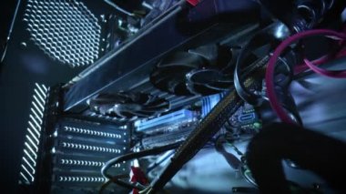 Eski bir bilgisayar sistemi biriminin içinden görüntüle. Kamera hareketi soğutuculara yakınlaşıyor. Kablolar, işlemciler ve toz parçacıkları ile bilgisayar yapısının arka planını kapat.