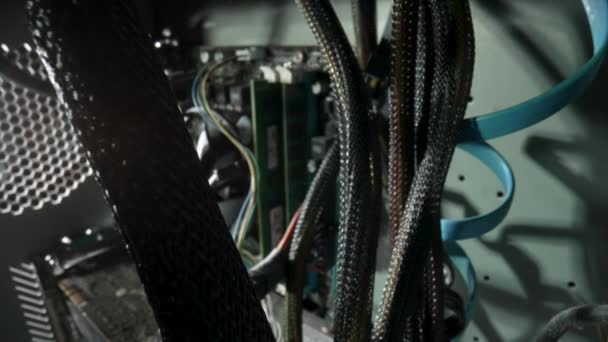 View from inside of an old dusty computer system unit. Camera movement among the wires. Close up background of computer structure with motherboard, cooler and memory slots covered with dust particles. — ストック動画