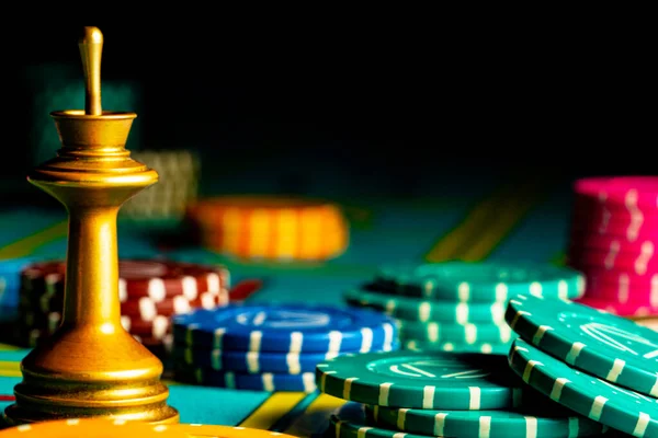 Un conjunto de fichas de colores en una mesa de juego de póquer en un casino sobre un fondo oscuro. Apuestas, riesgo, victoria. Concepto de juego, apuestas, ocio. Fondo de juego de póquer. Mesa de juego con fichas de cerca. —  Fotos de Stock