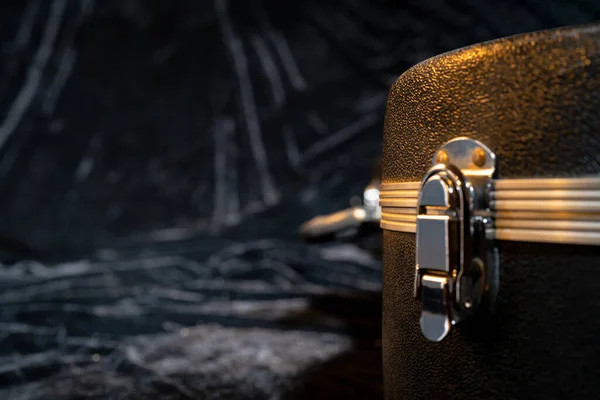 검은 색 벨로 직물 위에 놓인 기타를 다루는 검은색 하드 케이스의 일부입니다. 현악기를 위해 뚜껑을 닫고 닫는다. 음향 기타아 용 블랙 의상 트렁크. — 스톡 사진