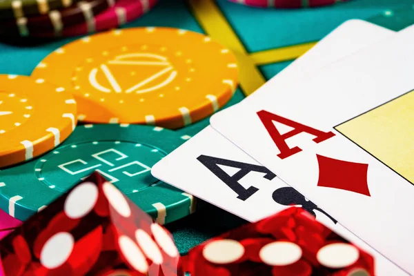 Speelkaarten, dobbelstenen en gekleurde poker chips van boven op de pokertafel in het casino. Het concept van gokken, wedden, vrije tijd. Spel achtergrond met twee azen en chips. close-up macro shoot. — Stockfoto
