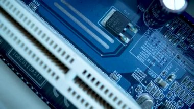 Mavi ışıkta bilgisayar anakart çipinin üst görüntüsü. Bilgisayar anakartındaki elektronik bileşenlerin detayları. CIP, slot, mikroçip ve mikroişlemcili ana bilgisayar elektrik devresi. Kapat.