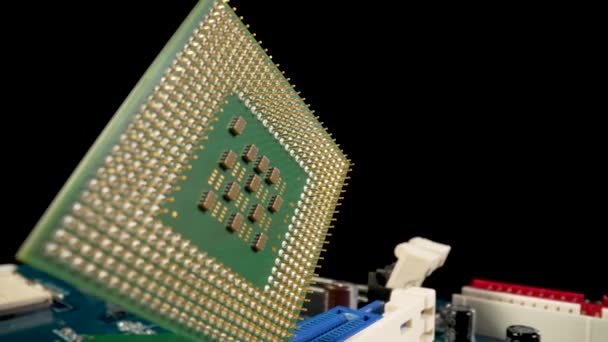 Grön dator CPU mikroprocessor eller processor på en svart bakgrund. Närbild av metalliska guldstift av datorprocessor. Datormoderkort med processor, kortplatser och induktionsspolar. — Stockvideo