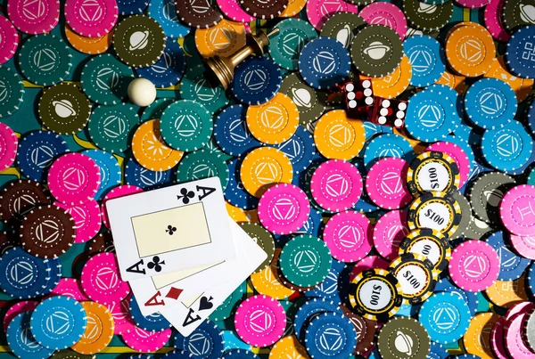 Horní pohled na pokerový stůl s žetony, kartami a kostkami pro hraní pokeru. Sada poker barevných žetonů, tři esa a červené kostky zblízka. Hazardní pozadí v kasinu. Poker club. Riziko, úspěch, vítězství. — Stock fotografie