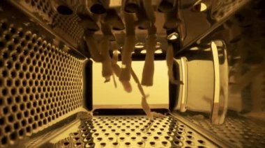 Mutfaktaki metal rendesinin içinde rendelenmiş peynir. Ürünleri ovalamak için keskin delikleri olan rende. Sarı arka planda gıcırdatmak için mutfak aleti. Kapatın. Restoran ya da kafe için arka plan.