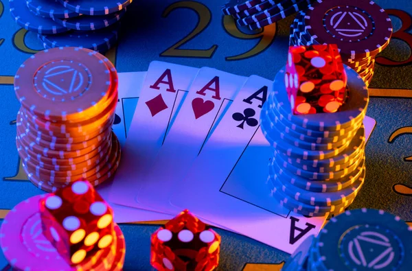 Un quad de cuatro ases, conjunto de fichas de colores y dados en la mesa de juego en el casino. Jugar a las cartas, fichas de póquer y dados rojos de cerca en la luz azul. Juego de azar, póquer, blackjack. —  Fotos de Stock