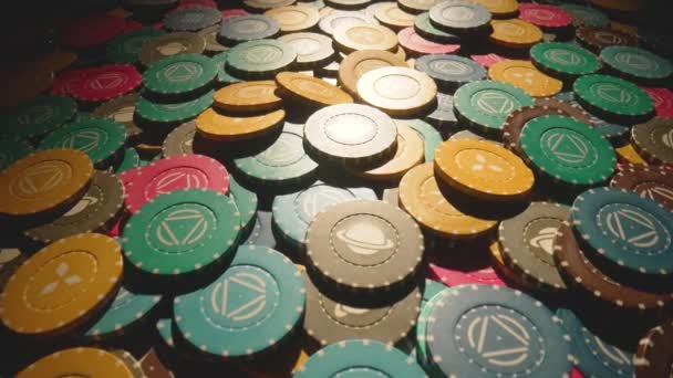 Heap of colored casino chips on a dark backlit table. Game chips for a casino close up. The concept of gambling and entertainment. Win, poker betting, roulette, blackjack. Camera movement. — стоковое видео