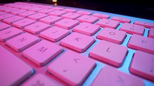 Keyboard of a laptop or computer illuminated with pink light. The concept of gambling, online betting in the casino. Playing poker, blackjack, roulette or Texas Holdem over Internet. Close up. — Stock Video