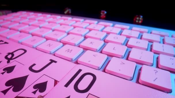 Computer keyboard and Royal Street Flush card combination, illuminated with pink light on black background. Concept of gambling, online betting in casino. Play poker or holdem over internet. Close up. — Stock Video