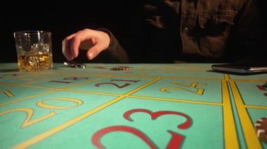 Riskli kumarbaz poker oynar ve son fiş ve araba anahtarlarını koyar. Tanımlanamayan erkek kumarhanede kumar masasında oturur ve viski içer. Bahis, eğlence, kumarhanede kumar. Kapat..