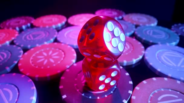 Red dice lying on a pile of casino chips spinning on a black background. Set for gambling, poker or blackjack close up. The concept of gambling, betting in the casino. Online casino on the Internet. — Vídeos de Stock