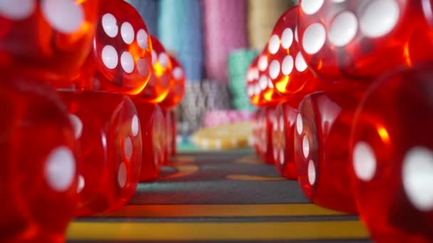 Camera moves along the rows of red dice and zooms in on the casino chips. Game table for gambling, poker, blackjack in the casino. Concept of betting, entertainment, leisure. Online casino. Close up. — Vídeos de Stock