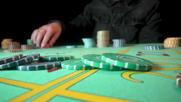 Неузнаваемый игрок делает ставки, сидя за столом рулетки в казино. Человек делает ставки, раскладывая фишки на игровом столе. Концепция азартных игр, рулетки, покера, ставок, богатства. Закрыть. — стоковое видео
