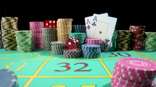 Set of colorful chips, playing cards and red dice on a gaming table for gambling in a casino. Dice falling on the table close up in slow motion. Poker set on a black background. — Vídeos de Stock