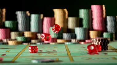 Kumarhanede kumar masasına kırmızı zarlar düşüyor. Siyah arka planda, bulanık çiplerle. Barbut, poker, blackjack. Bahis, eğlence, eğlence anlayışı. Ağır çekimde kapat..