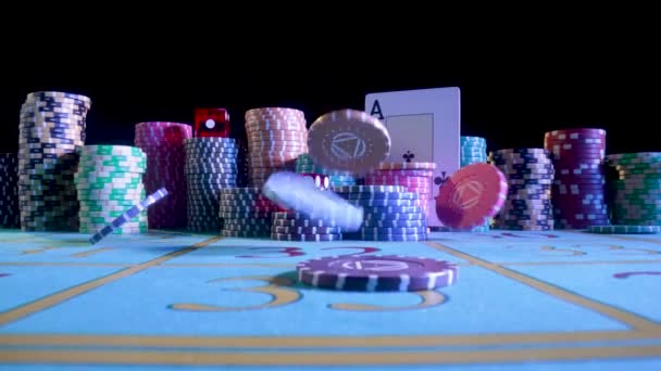 Набор разноцветных фишек, игральных карт и красных костей на игровом столе для игры в казино. Чипы казино падают на стол в замедленной съемке. Покер на черном фоне. — стоковое видео