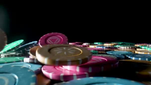 검은 배경의 카지노의 게임 테이블 위에 카지노 칩 이 있습니다. 느린 동작으로 가까이 붙어 있는 더미 위에 떨어지는 작은 물방울들. 도박 과 오락이라는 개념. 윈 , 포커 , 룰렛 , 블랙잭. — 비디오