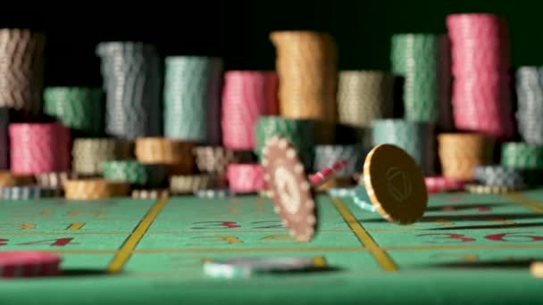 Casino chips falling on the gaming table on a black background with blurry stacks chips. Roulette, poker, blackjack. Concept of betting, entertainment, leisure. Close up in slow motion. — Vídeos de Stock